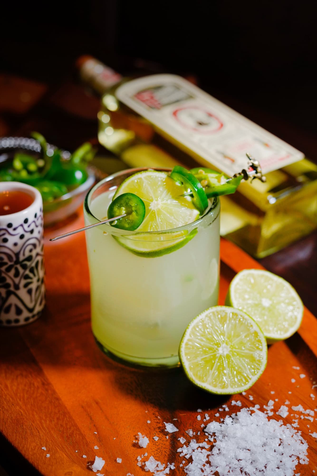 A Jalapeño Margarita on the rocks with a jalapeño slice and lime wheels