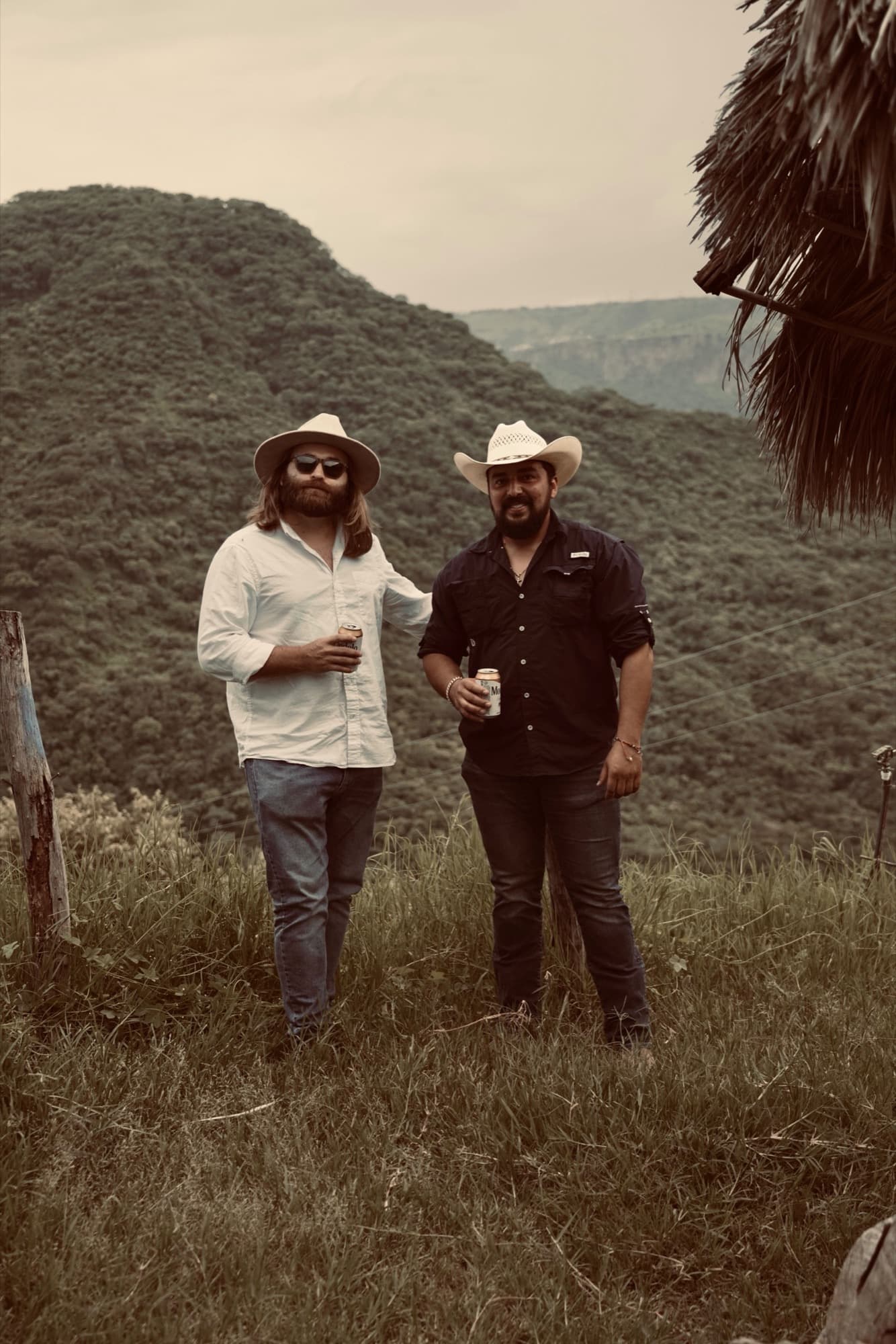 Peter Kiley and Omar Martinez standing on a grassy hillside above the estate