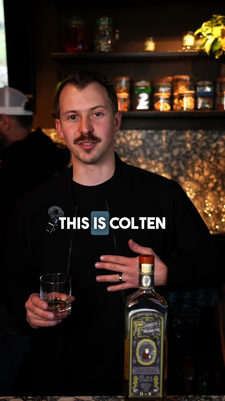 Colten at a bar with a glass of tequila and a bottle of Pedro Furtivo 1331 Añejo